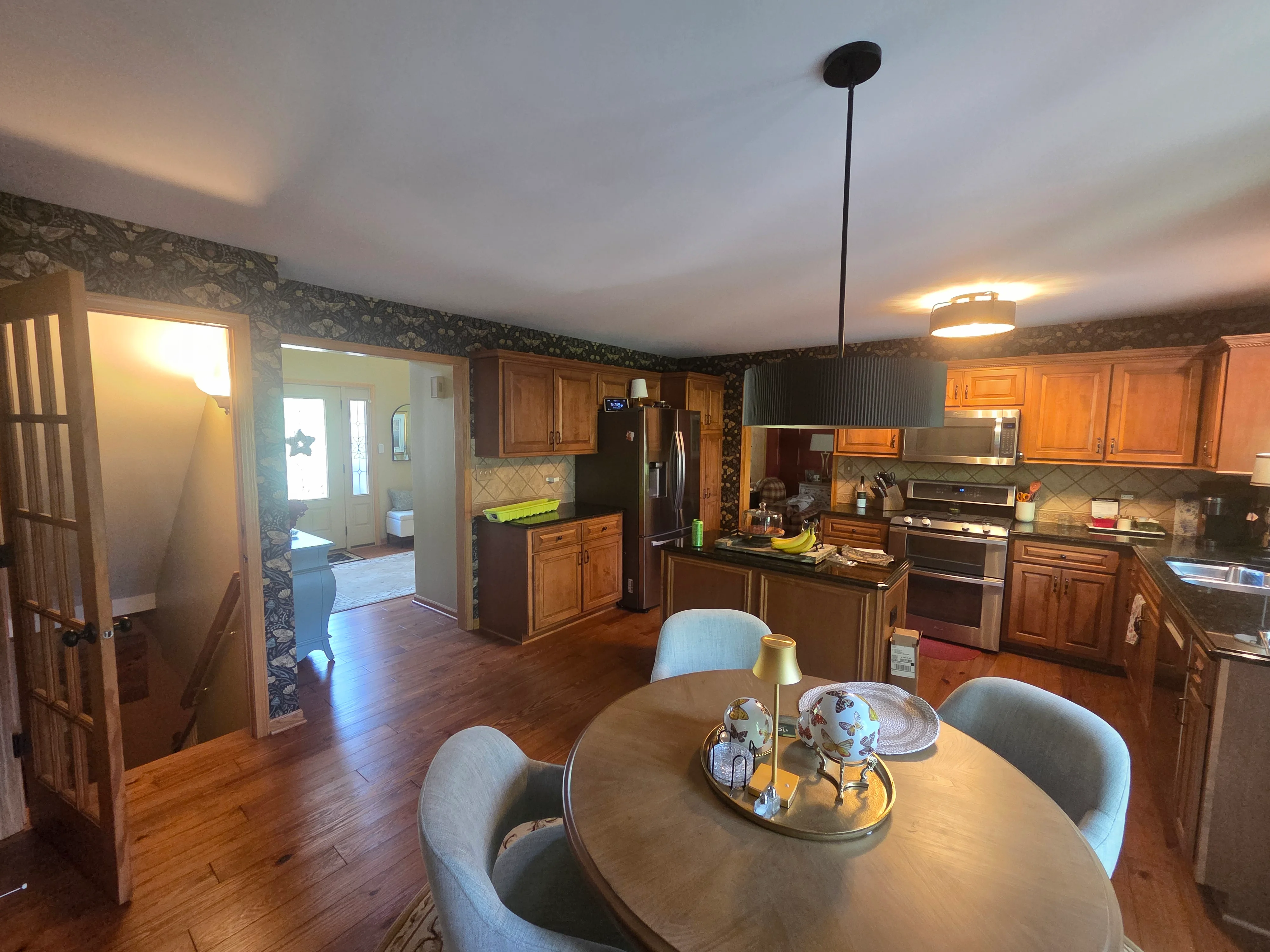 Kitchen with painted walls, ceiling, and wood cabinets; dining area with round table and painted trim