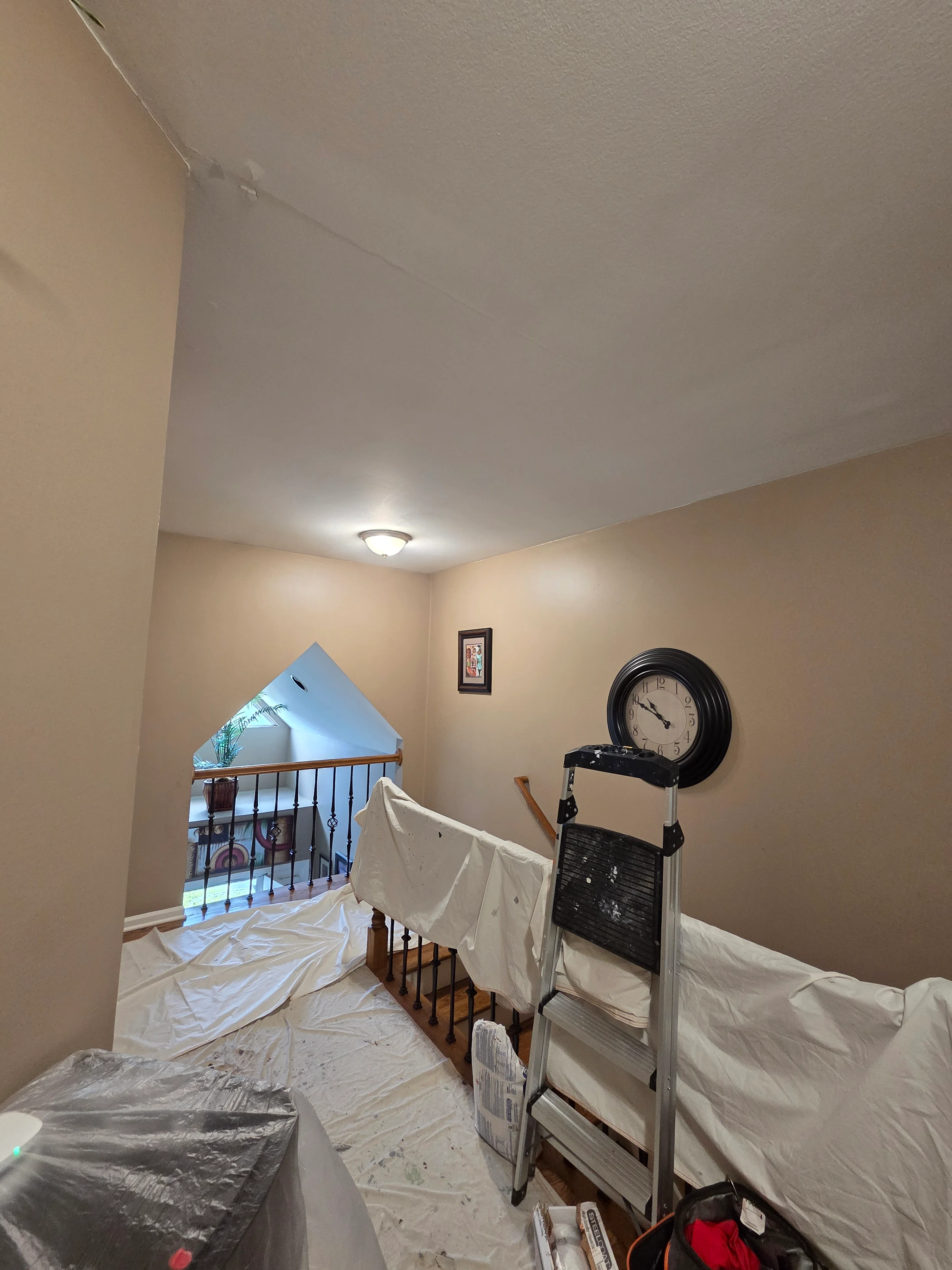 Freshly painted interior room with smooth drywall ceiling and beige walls, recessed lighting