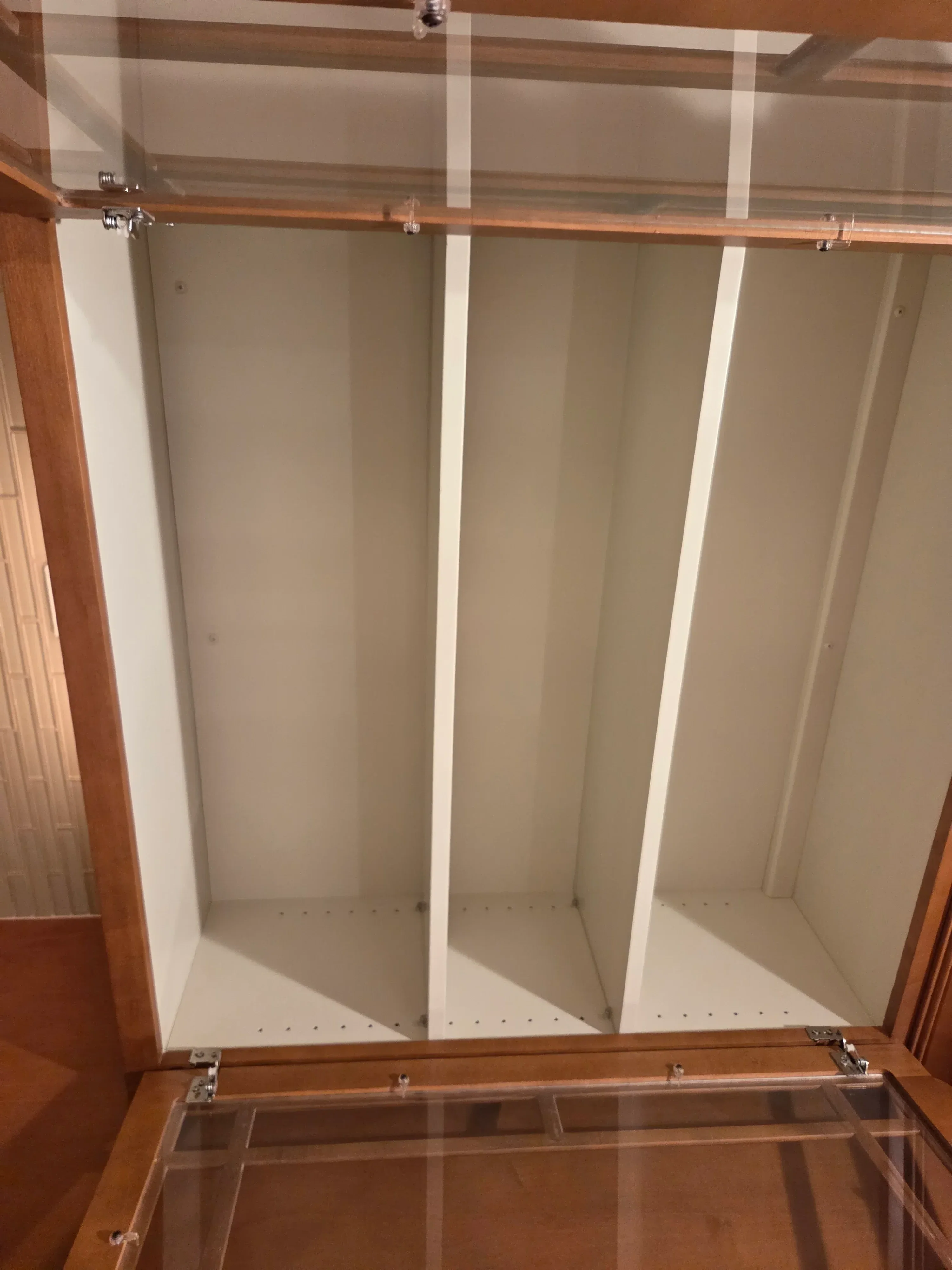 White painted cabinet interior with three shelves, wood frame, and glass doors