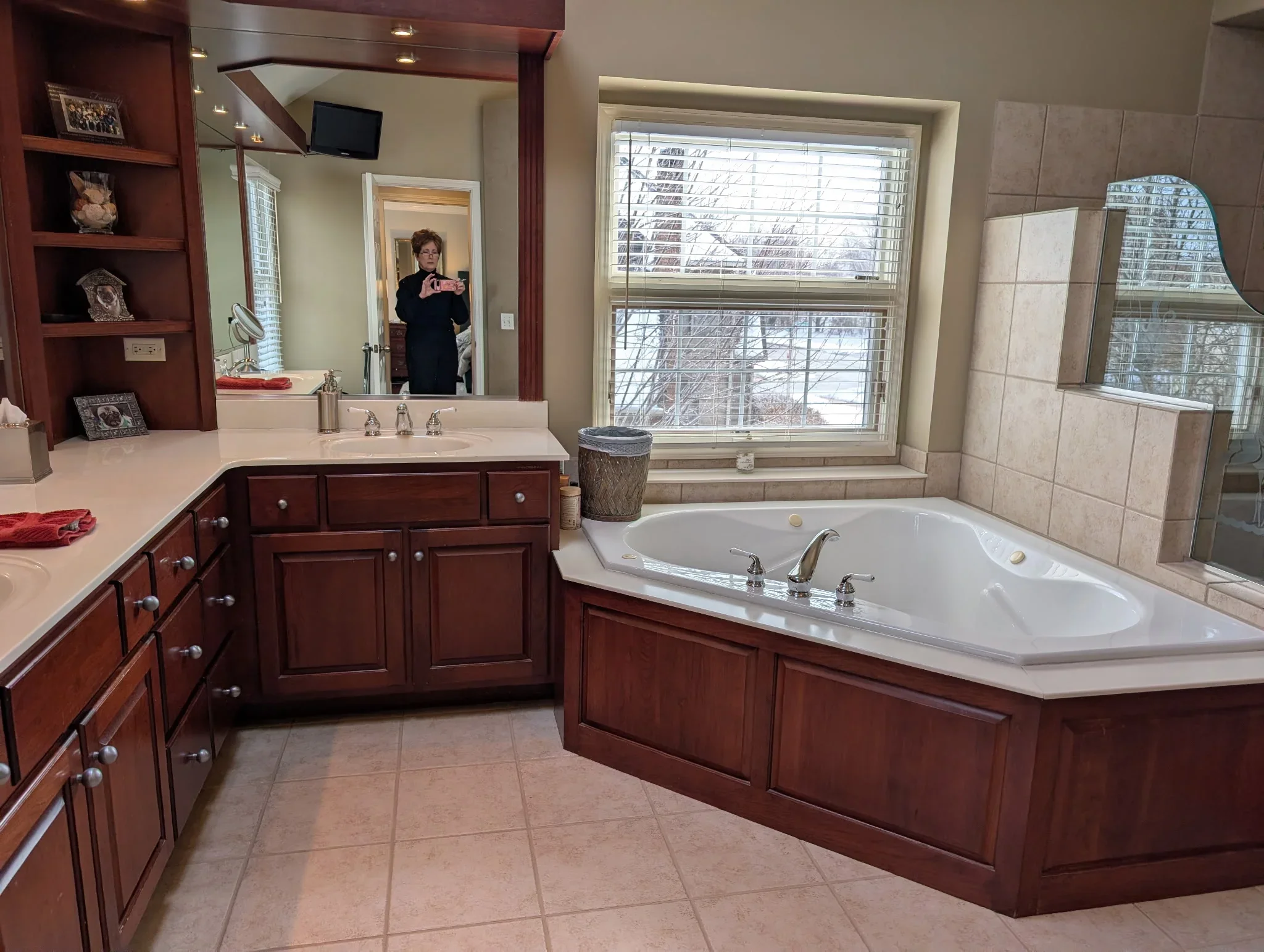 Master bathroom with burgundy painted cabinets, neutral walls, and white tile surround