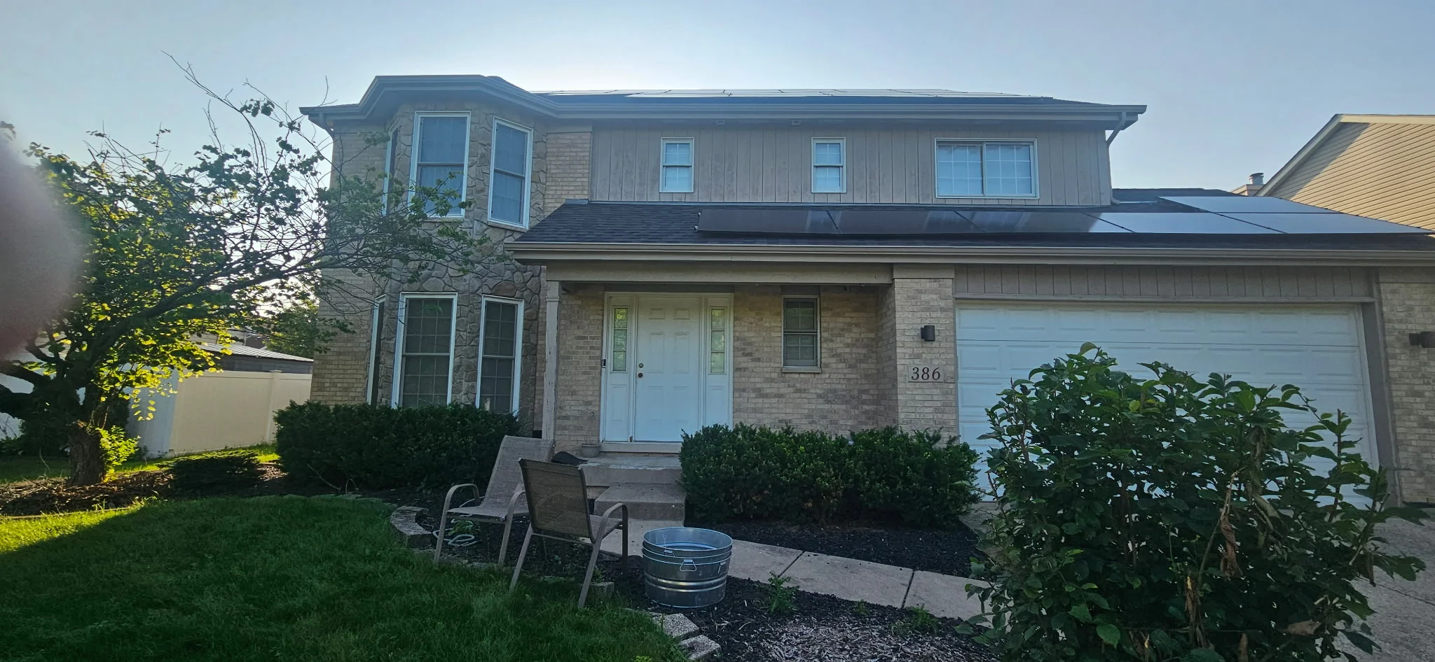 Two-story brick home with white trim, blue garage door, and freshly painted exterior