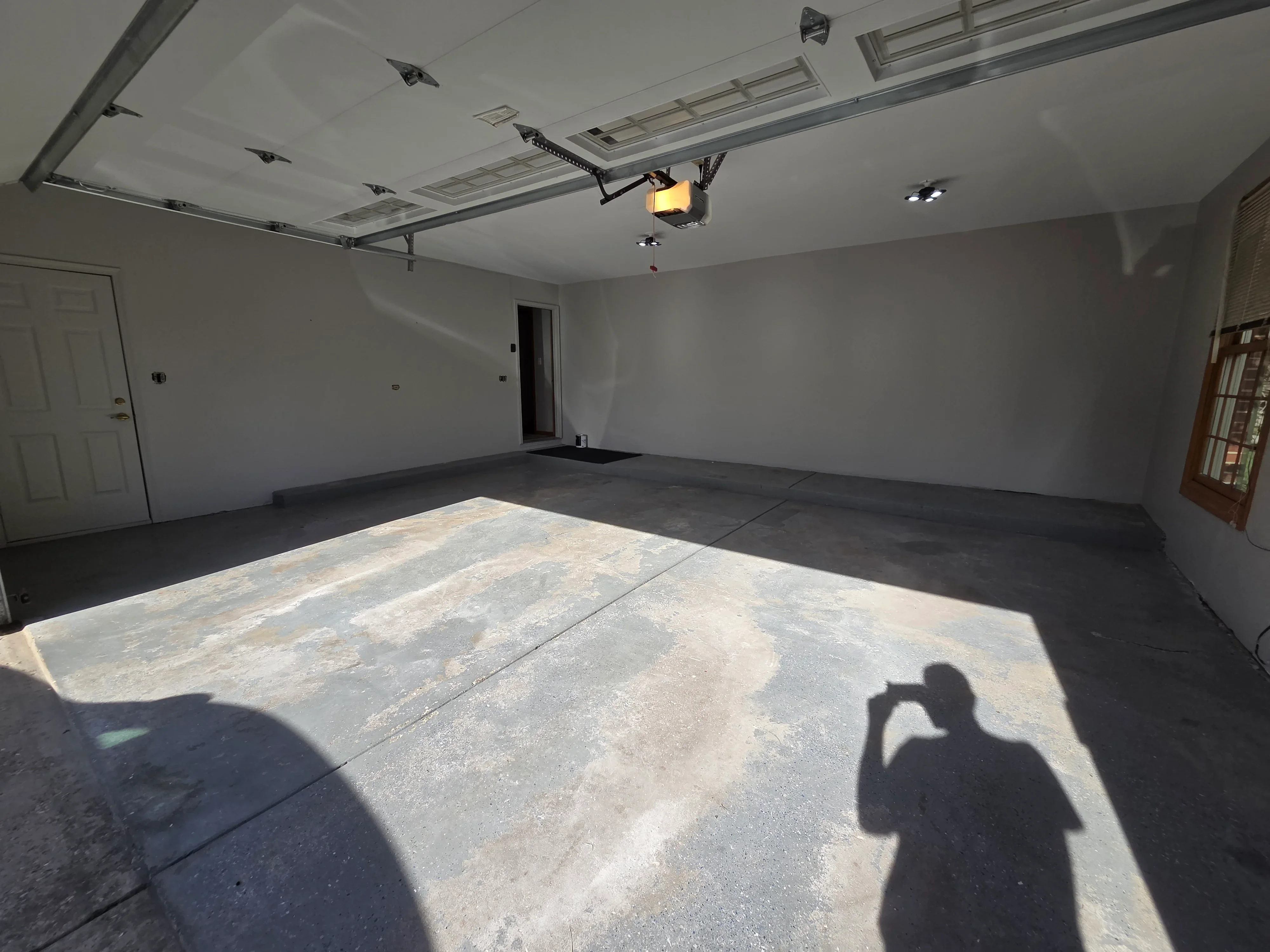 Finished garage interior with white drywall, recessed lighting, and concrete floor