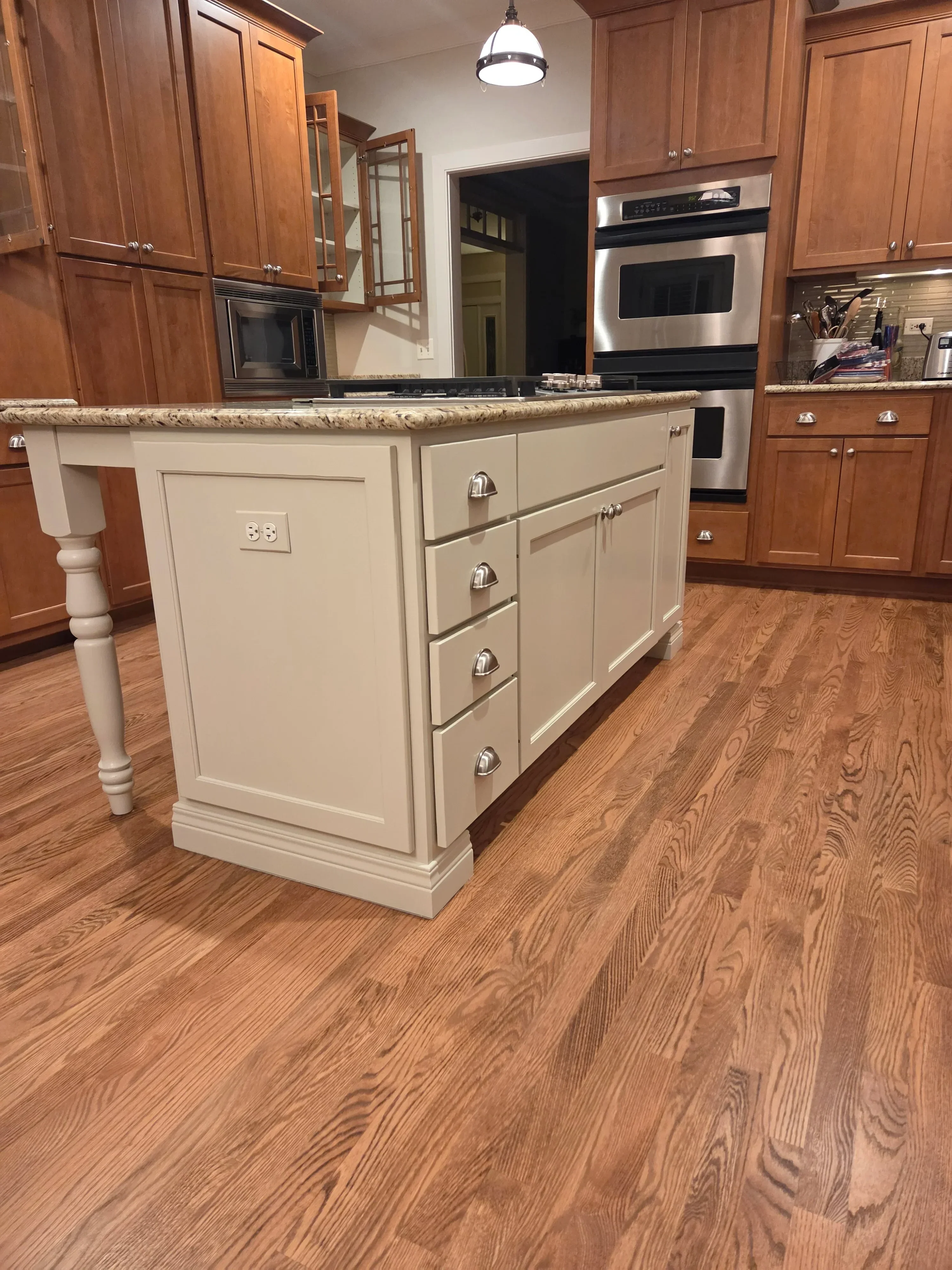 Cream painted kitchen cabinets with raised panels, chrome hardware, and decorative trim molding