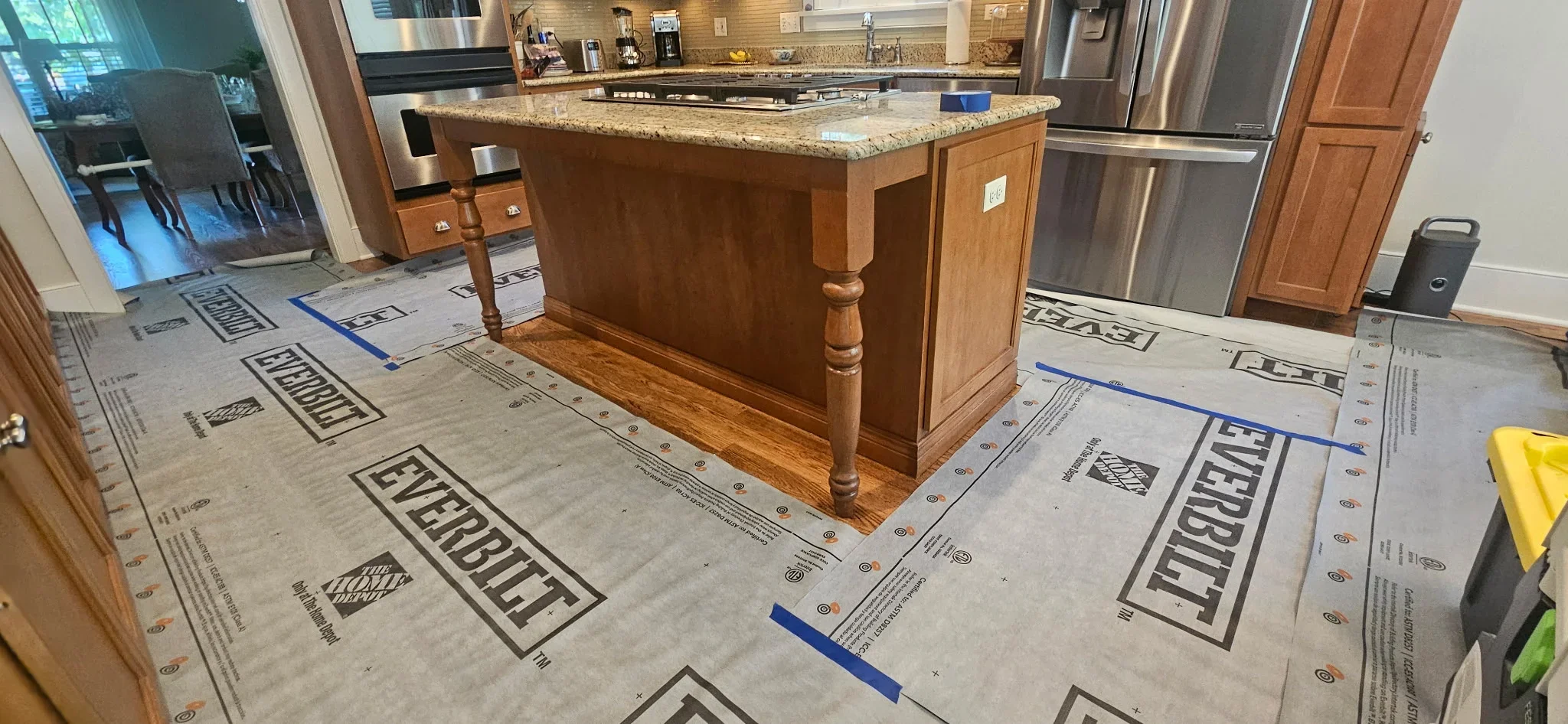 Wood kitchen island with granite top, protected flooring with kraft paper and painter's tape