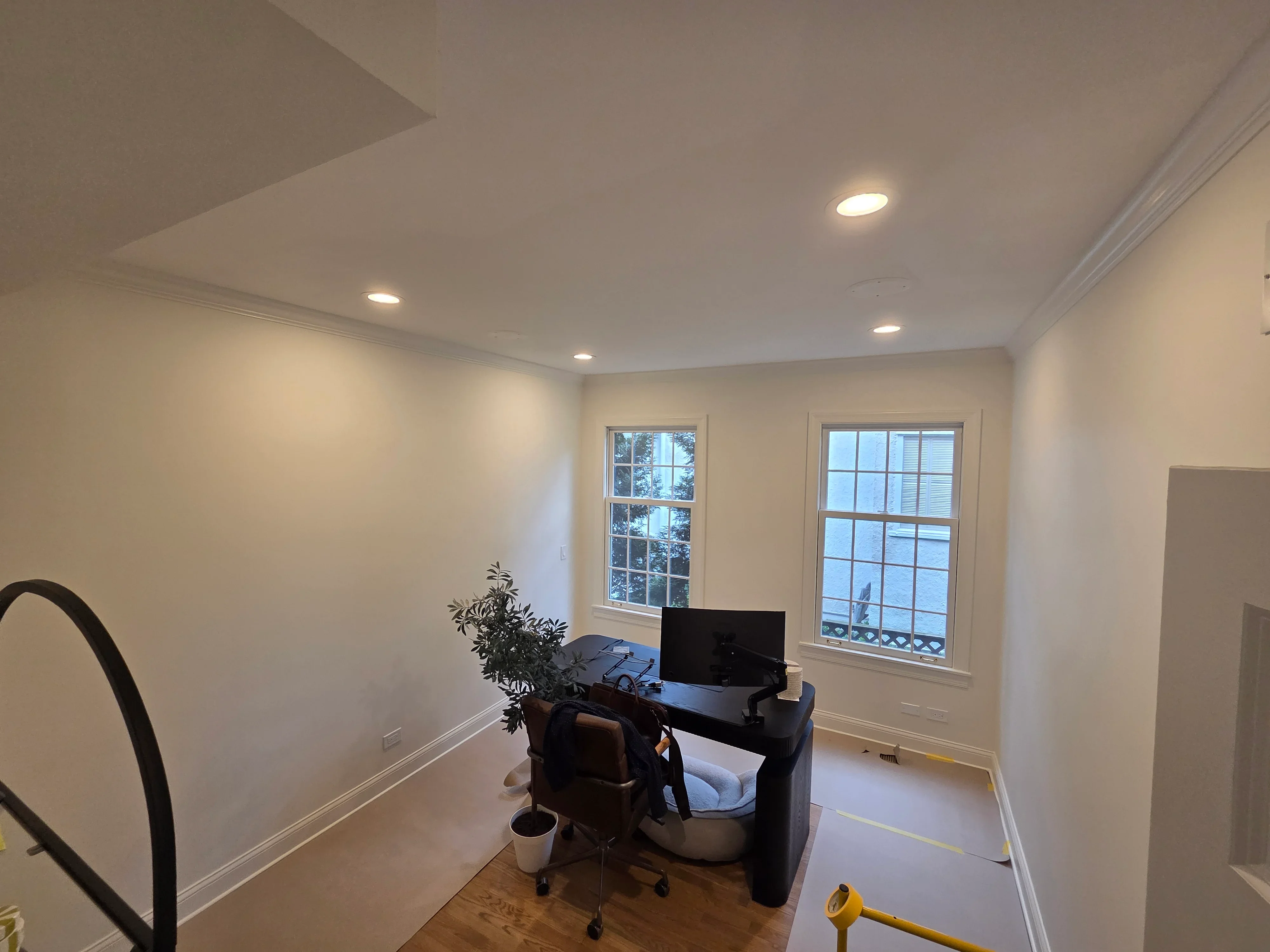 Freshly painted home office with beige walls, white trim, recessed lighting, and hardwood flooring