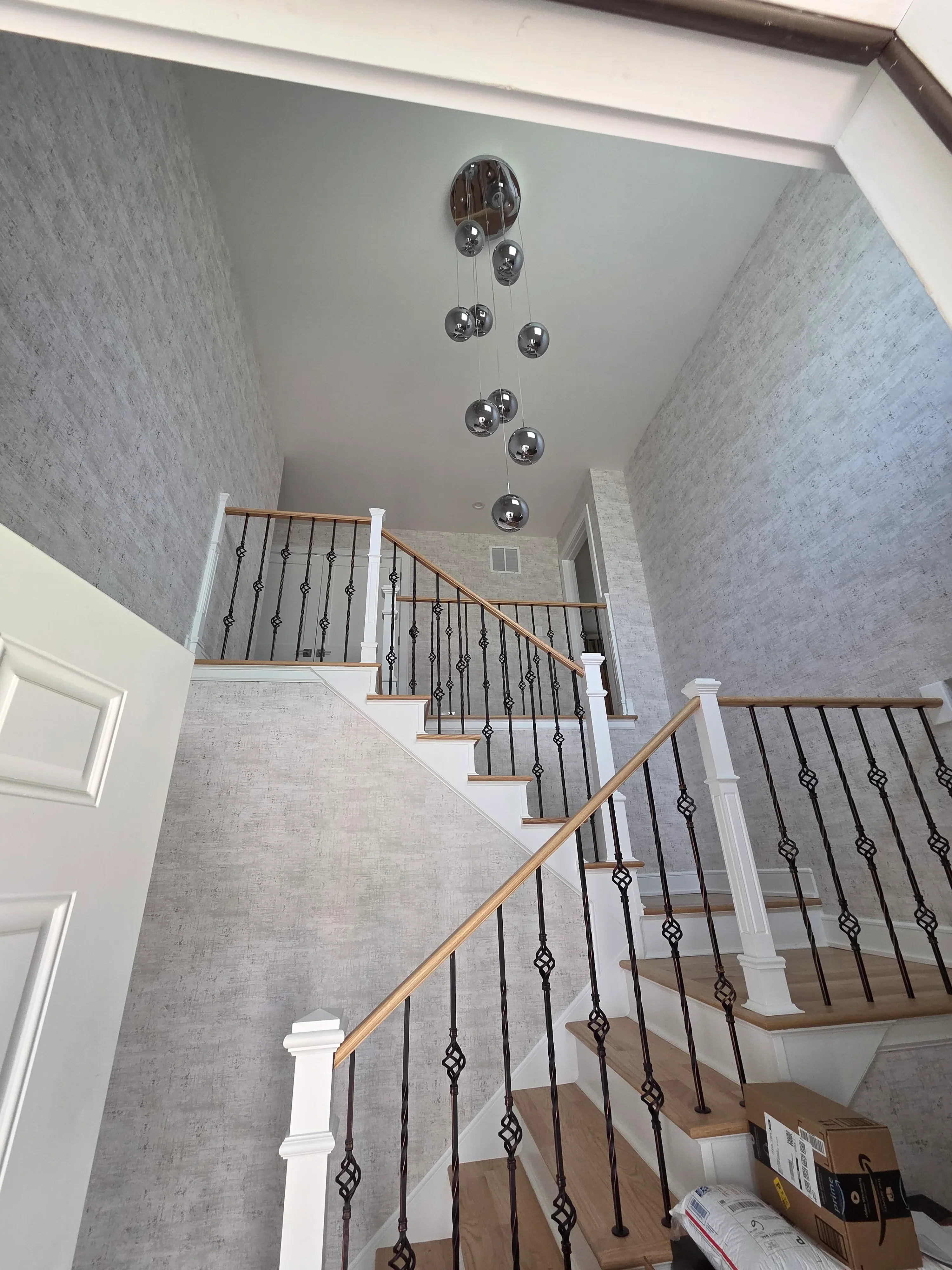 Painted staircase with gray walls, white trim, concrete ceiling, and metal railings