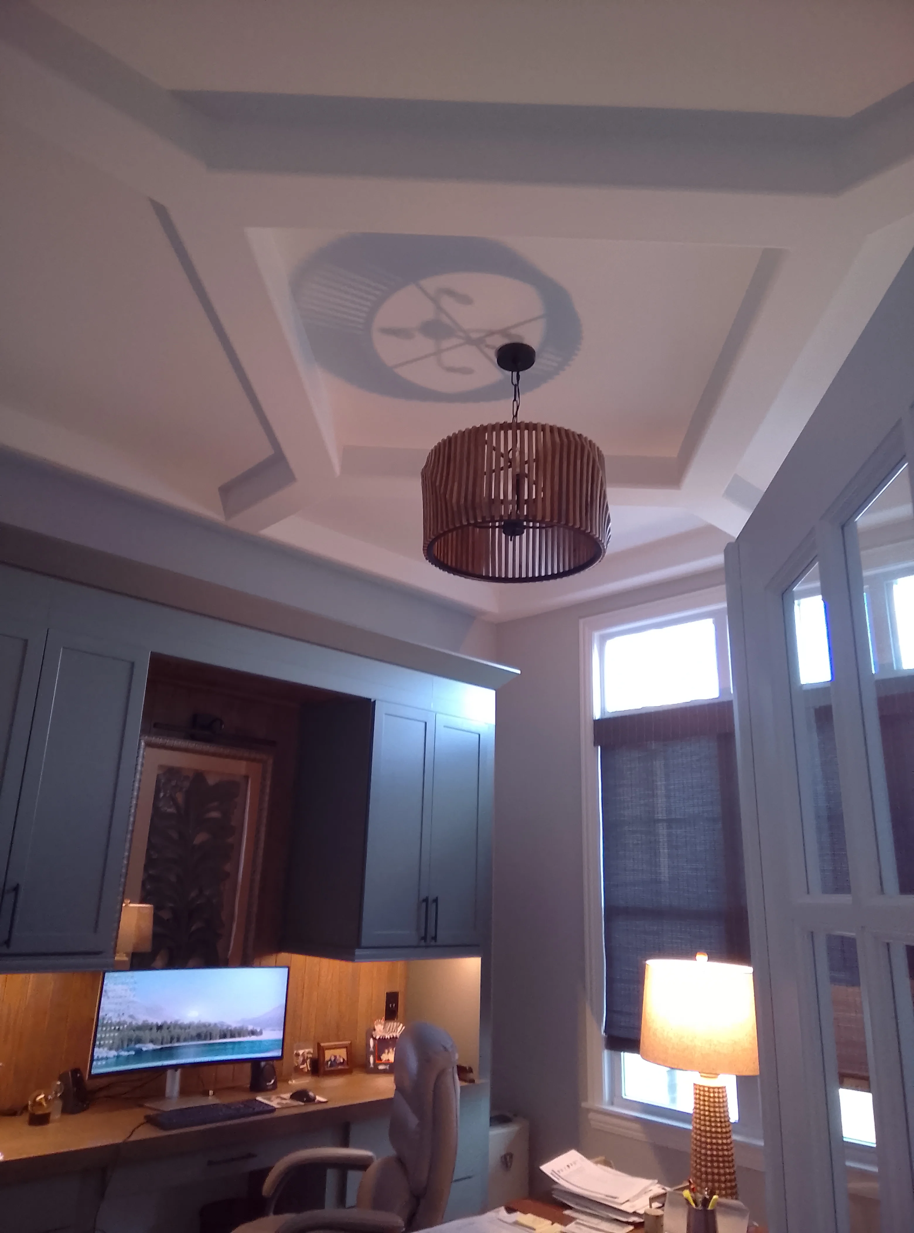 Coffered ceiling with white painted beams, recessed lighting, and bronze pendant fixture in home office