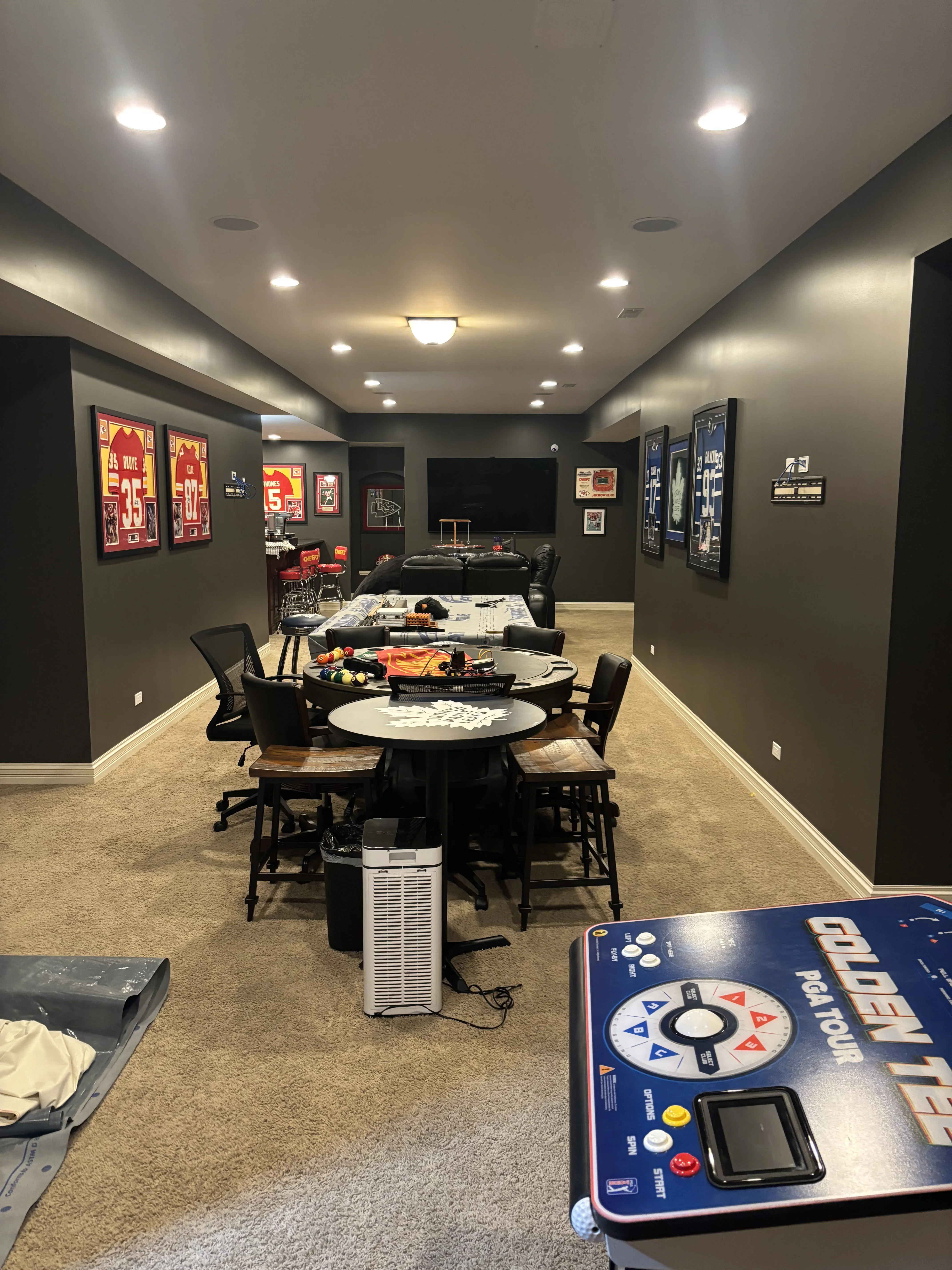 Charcoal gray walls with white trim and recessed ceiling lights in finished basement game room