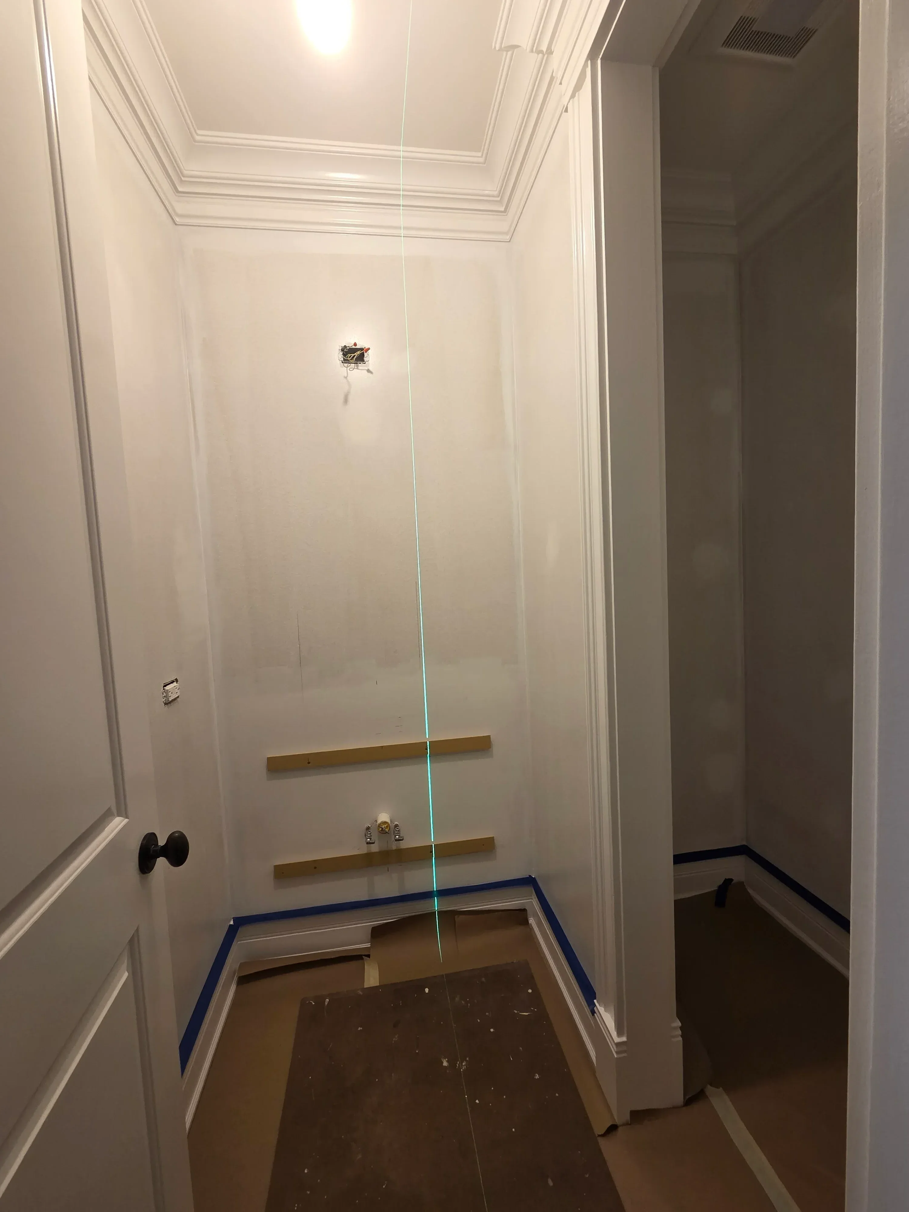 White drywall with finished seams, electrical outlet boxes, and primer/paint application in progress