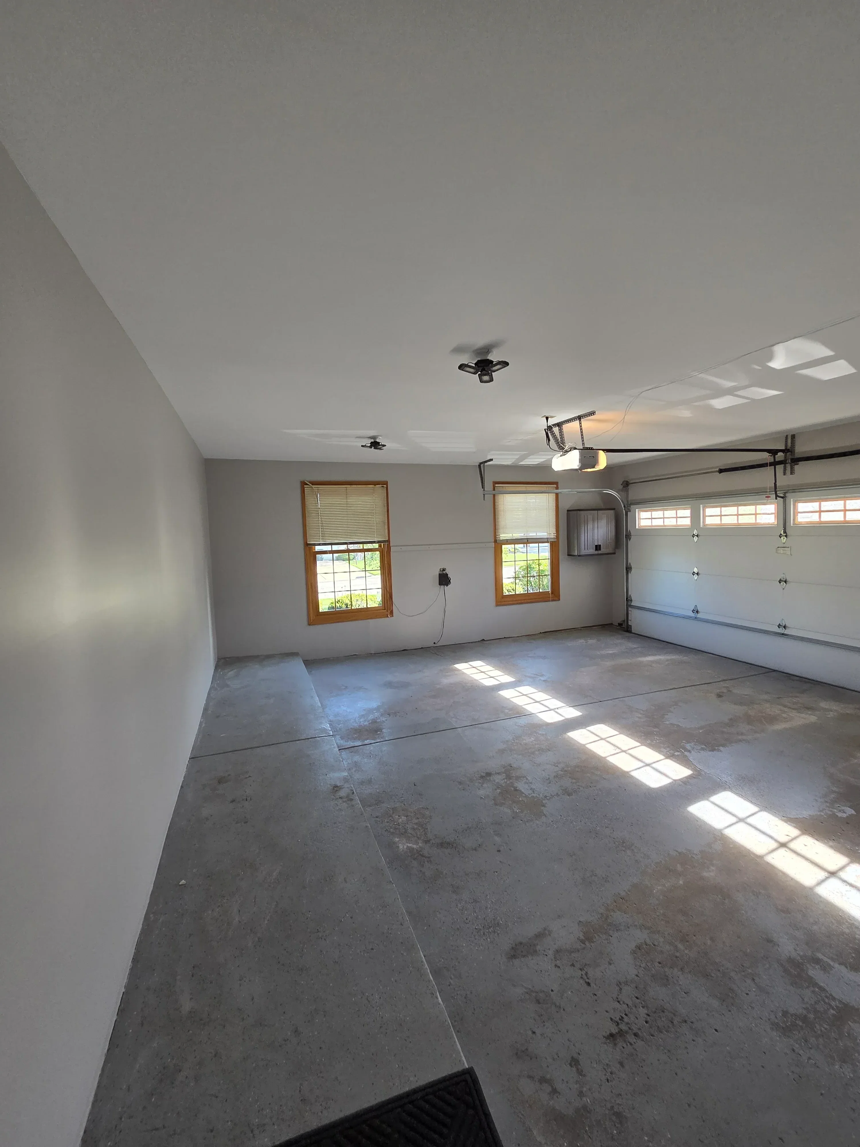 Drywall finished interior room with smooth painted walls, recessed ceiling lights, and wooden-framed windows