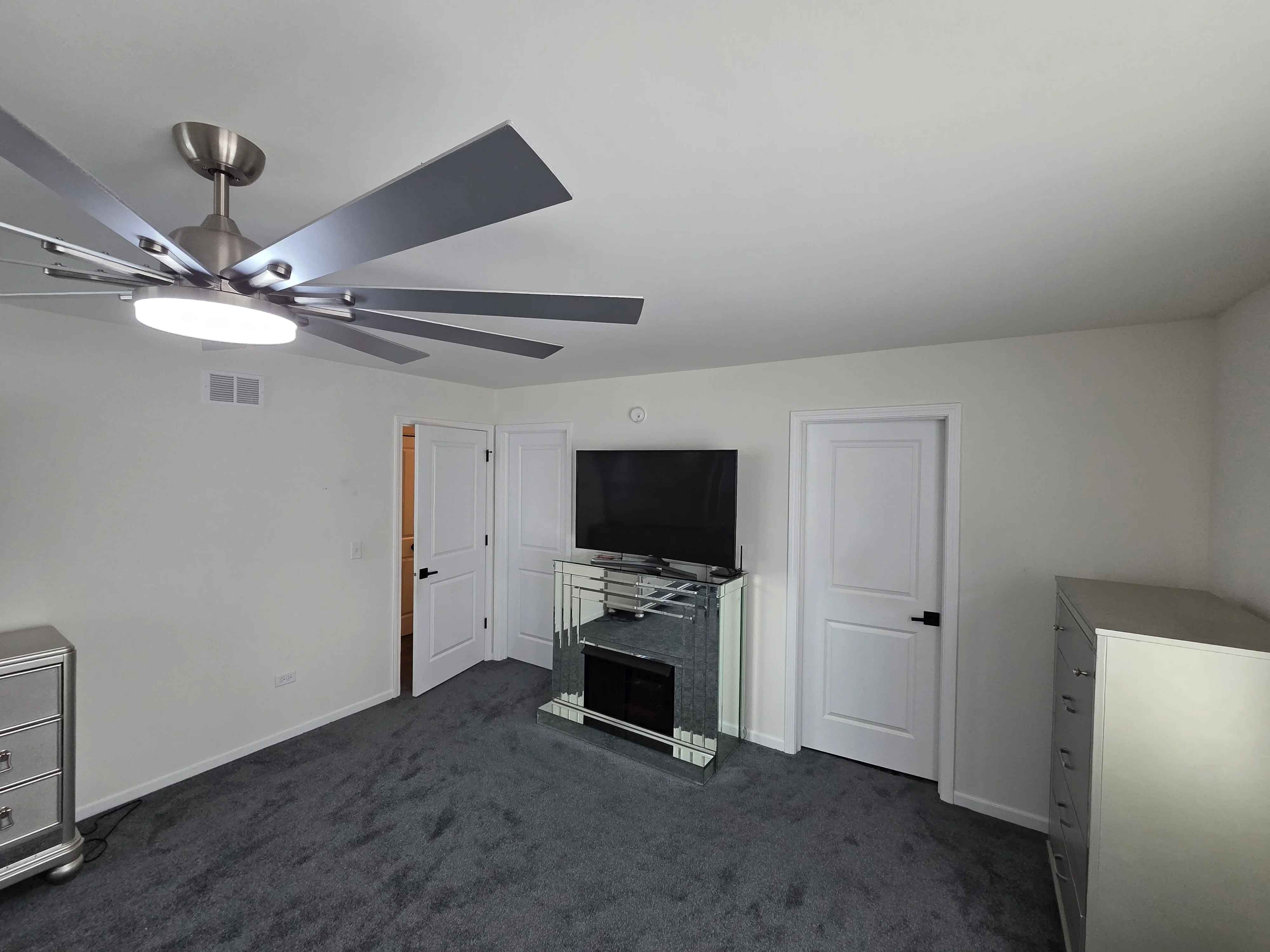 Freshly painted bedroom with white walls, ceiling, and trim around white six-panel doors